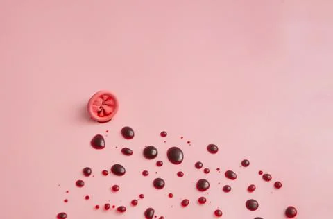 Metaphor of the anus on a pink background. Rectal bleeding, hemorrhoids. Stock Photos