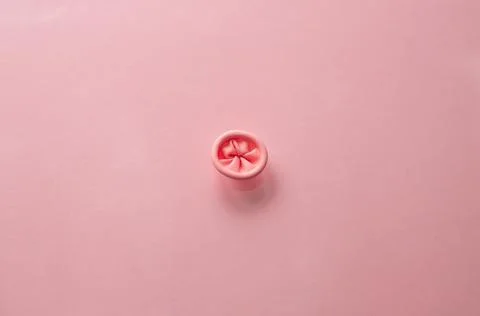 Metaphor image of the anus on a pink background. Rectal health, anus hygiene. Stock Photos