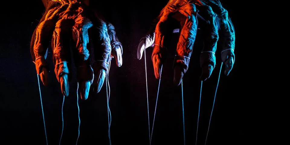 Metaphorical paws of the devil with threads for control 스톡 사진