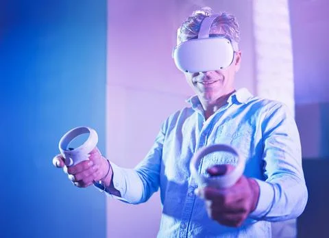 Metaverse, virtual reality headset or gaming console for mature man in neon 库存照片