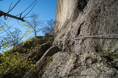 Meteora Greece rock face with cable handrail and budding trees Stock Photos