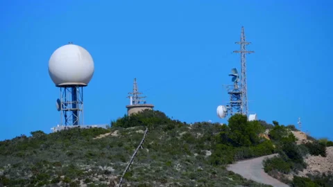 A meteorological radar with a large white sphere on top of a mountain Stock Footage 104066170