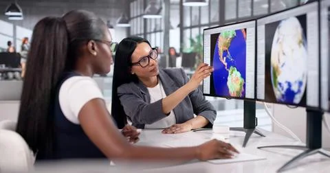 Meteorologist Studies Storm Maps On Computer During Teamwork Discussion. Stock Photos