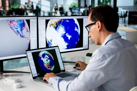 Meteorologist Studies Weather Patterns On Computer To Forecast Storm Risks. 库存照片