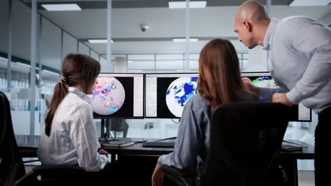 Meteorologists Analyzing Climate Data On Computer Screens Stock Footage 328394098