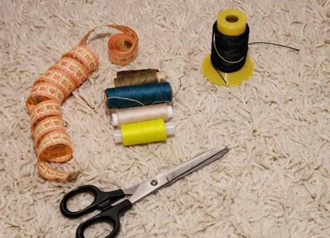 Meter, scissors, multi-colored spools of thread lie on a white background Stock Photos