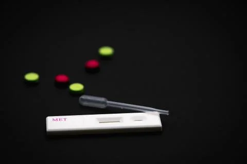 Methamphetamine cassette test with plastic dropper and green, pink drugs on b 库存照片