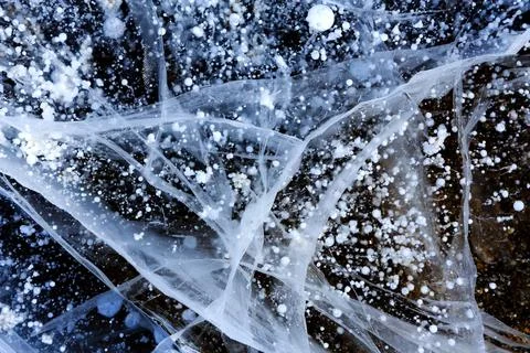 Methane bubbles in the Baikal ice. Cracks on the surface of lake. Stock Photos