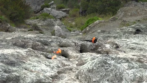 Methane flames burst from rocky ground cracks, natural gas fire - Surface Flame Stock Footage 339818648