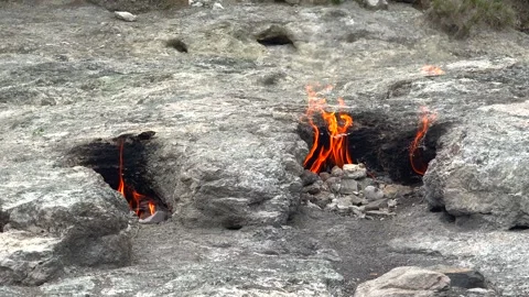 Methane flames burst from rocky ground cracks - Gas Combustion and Surface Flame Stock Footage 339818660