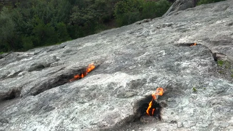 Methane flames burst from rocky ground cracks, natural gas fire - Gas Vent Stock Footage 339818677