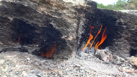 Methane gas fire burns between rocks - Eternal Flames and Geological Phenomenon Stock Footage 339562636