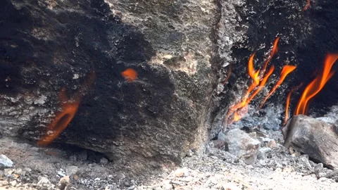 Methane gas fire burns between rocks on barren - Geology Fire and Energy Source Stock Footage 339562677