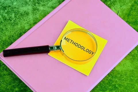 METHODOLOGY CONTEPT. METHODOLOGY word through a magnifying glass on a yellow  Stock Photos