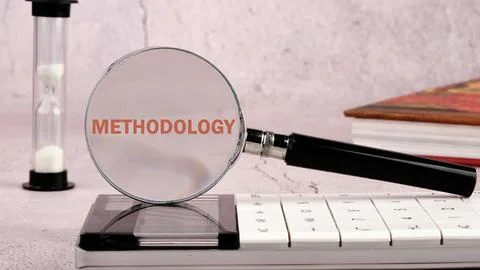 METHODOLOGY CONTEPT. METHODOLOGY word through a magnifying glass on a calcula Stock Photos