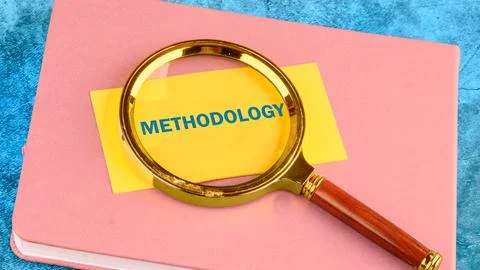 METHODOLOGY CONTEPT. METHODOLOGY word on a yellow business card with a magnif Stock Photos