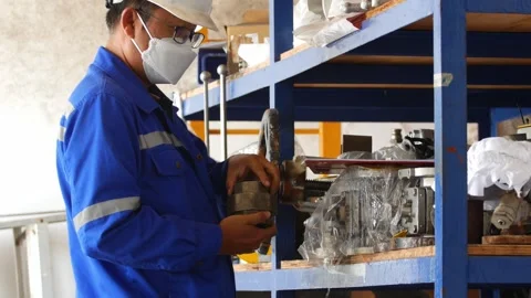 Meticulous Inspection. Engineer Assessing Machine Parts in Workshop Stock Footage 246435035