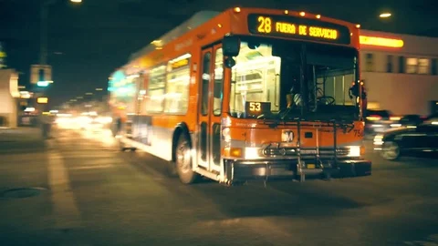Metro bus crossing street intersection on Melrose in Los Angeles at night. Video stock 82415204