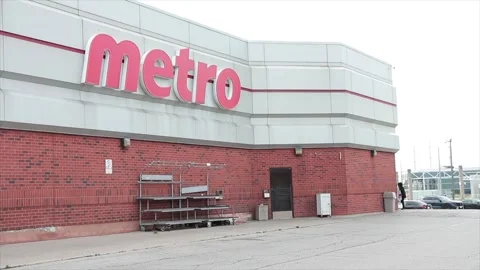 Metro grocery store chain side parking back lot with cars parking in front Stock Footage 249752608