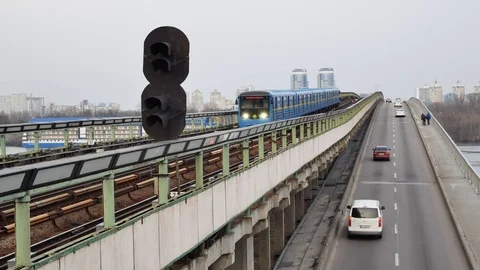 Metro line and the old blue train passing over the bridge with the road Stock Footage 105329372