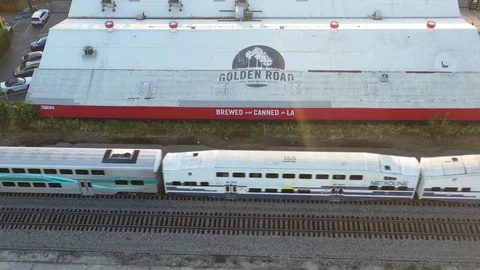 Metro link train passing in front of Golden Road brewery. Video stock 122013616