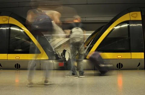 Metro station interior with two stopped trains and passengers in motion blur Stock Photos