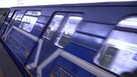 The metro train arrives at the platform and stops. Blue metro cars pass quickly. Stock Footage 128167797