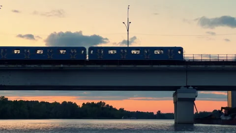 Metro Train Crossing River Bridge at Sunset | Silhouette of City Subway Stock Footage 344824931