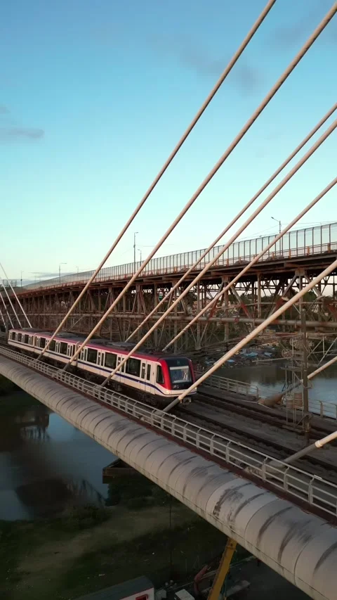 Metro train crossing suspension bridge in Santo Domingo. Aerial, Vertical format Stock Footage 337167514