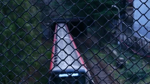Metro train leaving the tunnel view through the fence Stock Footage 260527424