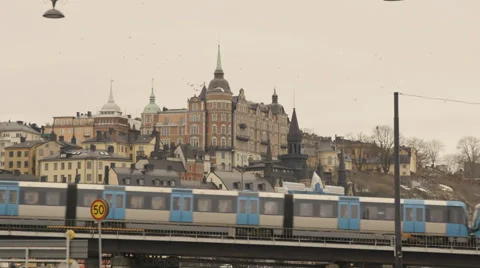 Metro train moving on bridge in cityscape Stock Footage 65875078