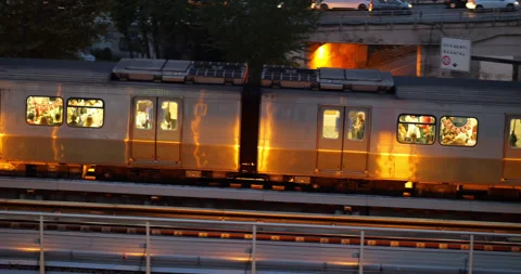 Metro train with passengers ride at elevated track, golden reflection at hull Stock Footage 318676677