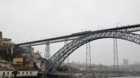 Metro Train passes over Dom Luis Bridge on a rainy day in Porto, Portugal Stock Footage 104268676
