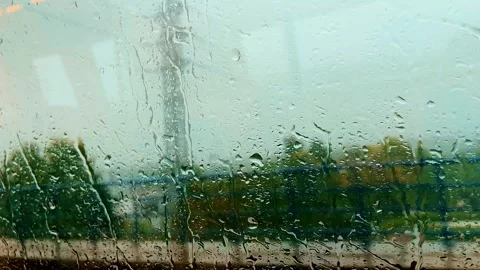 Metro Train Passing Behind Rain Covered Window on a Rainy Day Stock Footage 341723131