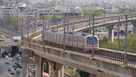 A metro train passing on the bridge with busy city road in the back  Stock Footage 241577624
