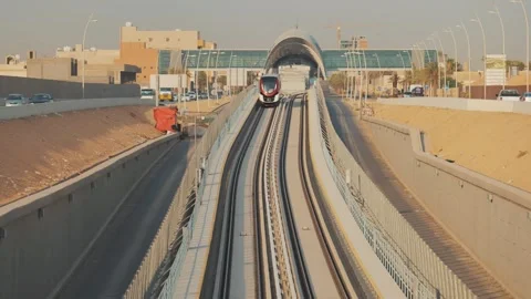 A metro train rides to a modern station in the city of Riyadh Stockbeeldmateriaal 305356076