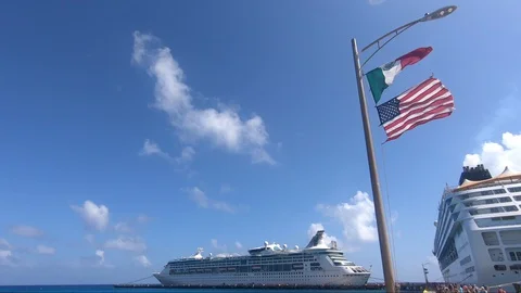 Mexican and American flags flying together at cruise ship terminal in Mahahua Stock Footage 127595732