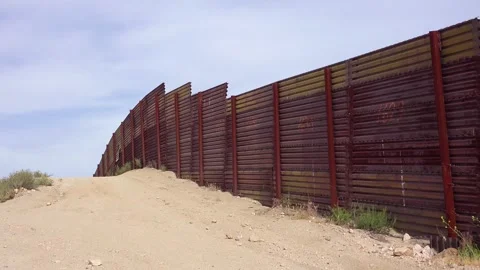 Mexican border wall fence stands along ridge line in southern California de.. Stock Footage 337752120