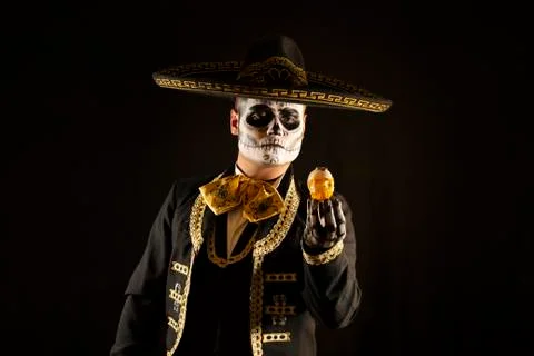 Mexican charro holding a candy skull in his hands on day of the dead Stock Photos