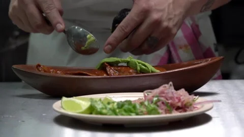 Mexican chef put avocado on top of hardshell tacos on boat plate Stock Footage 242389026