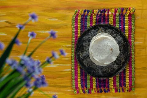 Mexican Comal Cookware flat Griddle and Tortillas on Woven Tablecloth. Stock Photos