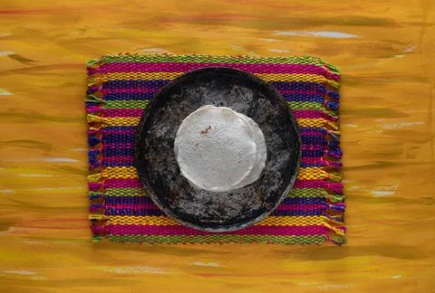 Mexican Comal Cookware flat Griddle and Tortillas on Woven Tablecloth. Stock Photos