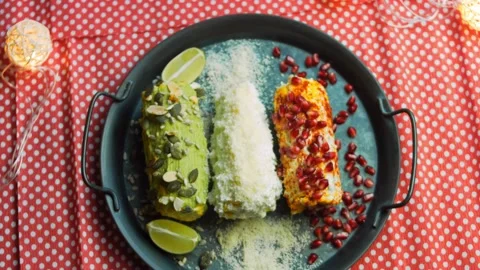 Mexican corn elote in three ways. Pressed with cheese, guacamole and pomegranate Stock Footage 170433733