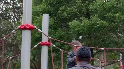 Mexican Father and Son Playing on a Rope Bridge in a Park Vídeos de archivo 343345329