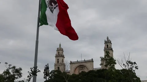 Mexican flag waving in the cathedral in merida yucatan mexico Stock Footage 304909622