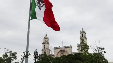 Mexican flag waving in the cathedral in merida yucatan mexico Stock Footage 304910394