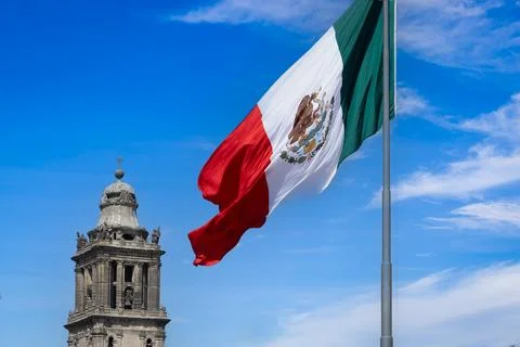 Mexican flag waving on Constitution Square with the Metropolitan Cathedral in Stock Photos