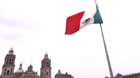 Mexican flag waving in front of the Metropolitan Cathedral in Mexico City. Stock Footage 342557493