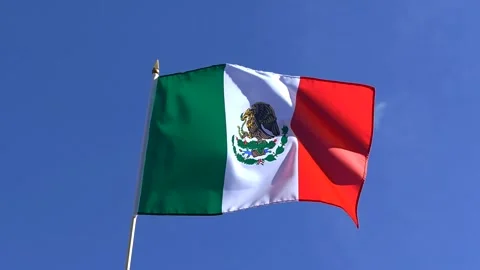 The Mexican flag waving in the wind in the blue sky Stock Footage 282432839