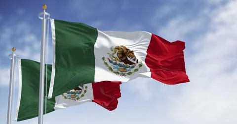 Mexican flags with its coat of arms waving against a blue sky. Stock Illustration